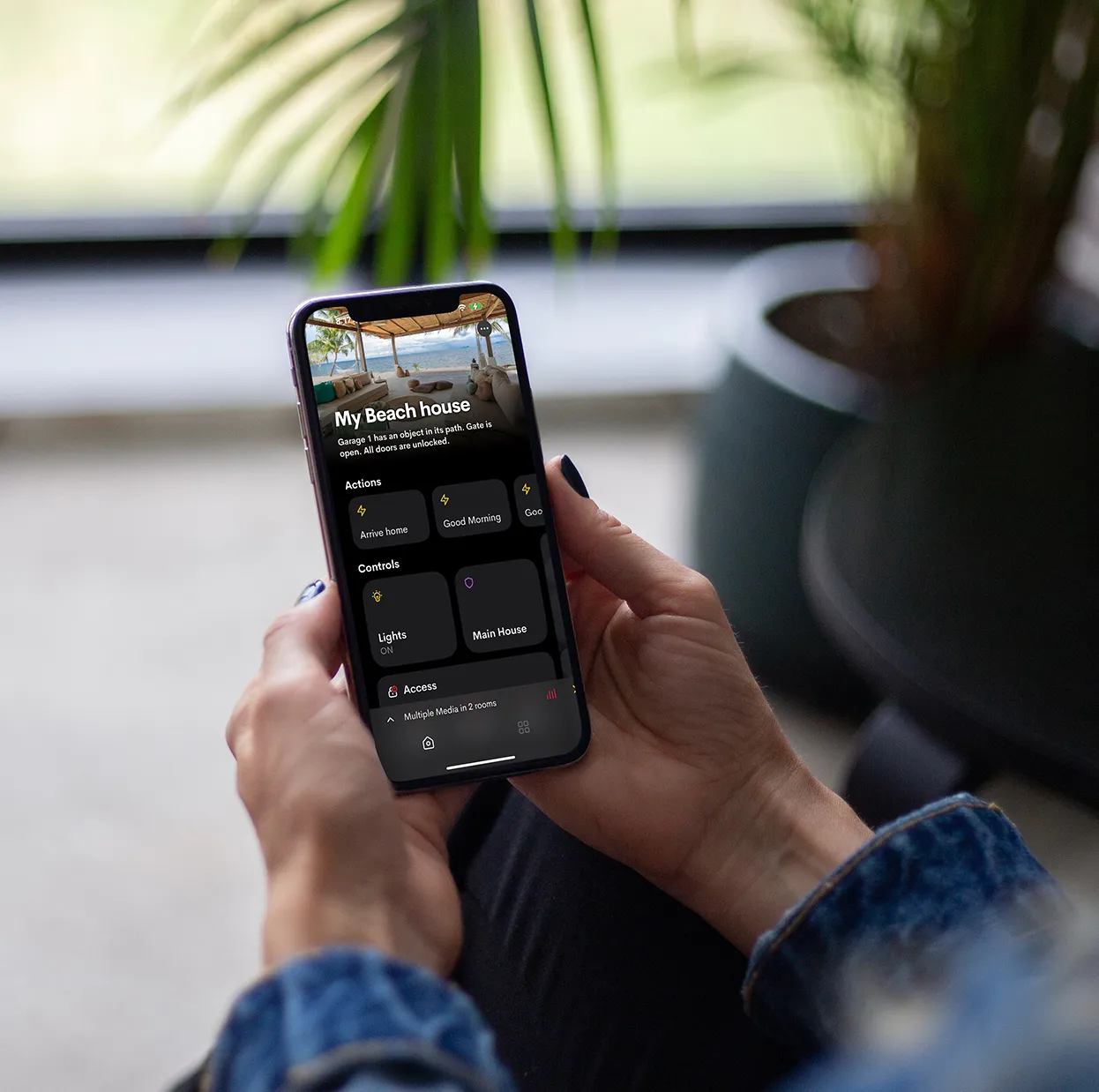 User managing a smart home control system through a smartphone app.