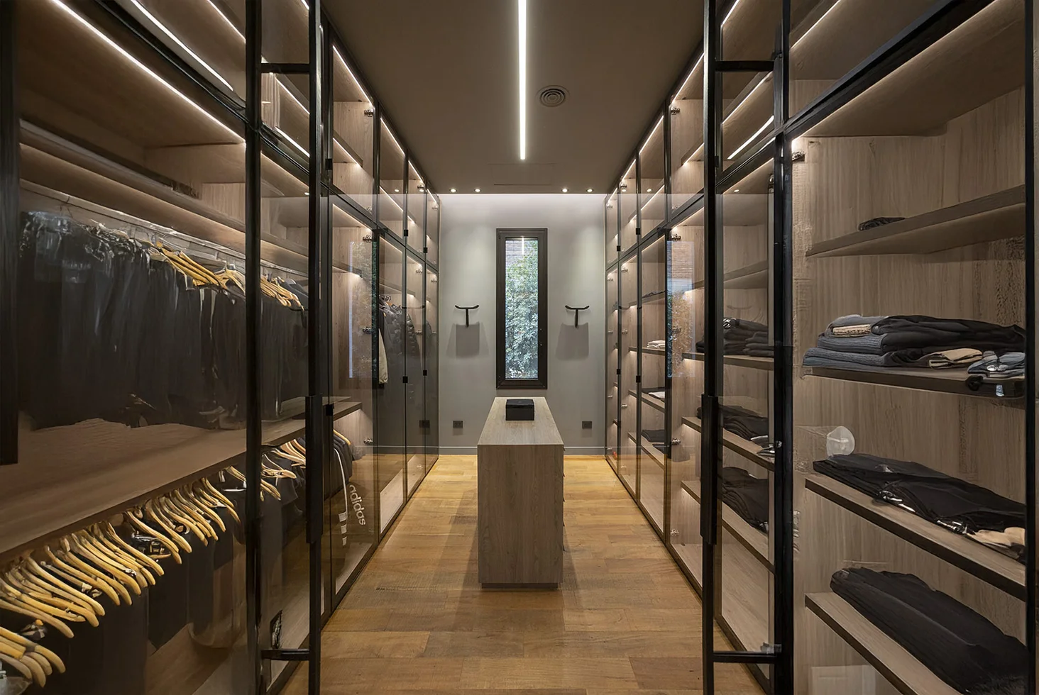 Highland Park residential walk-in closet with glass wardrobes.